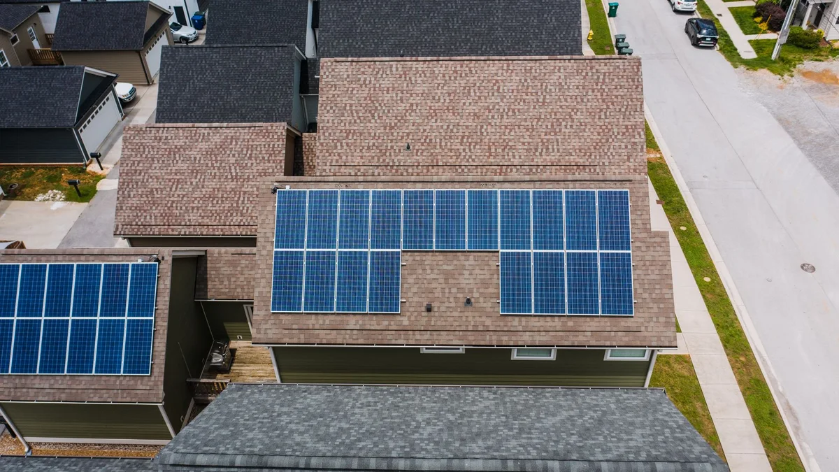 Beispielhafte Luftaufnahme eines Wohnhauses mit Solarmodulen.